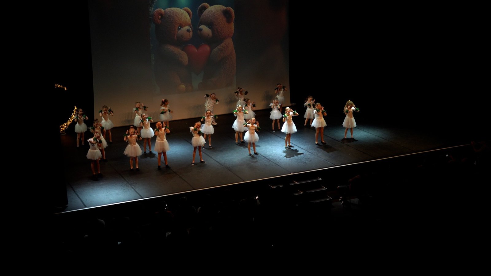 Un groupe d’enfants en tutu blanc sur la scène du gala